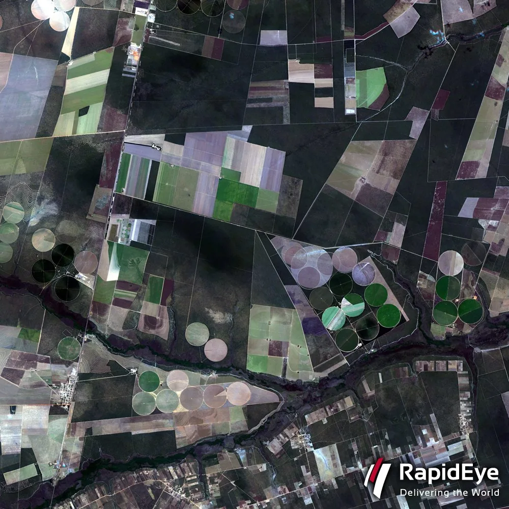 Aerial photo comparing well-defined agricultural plots with organically shaped natural vegetation